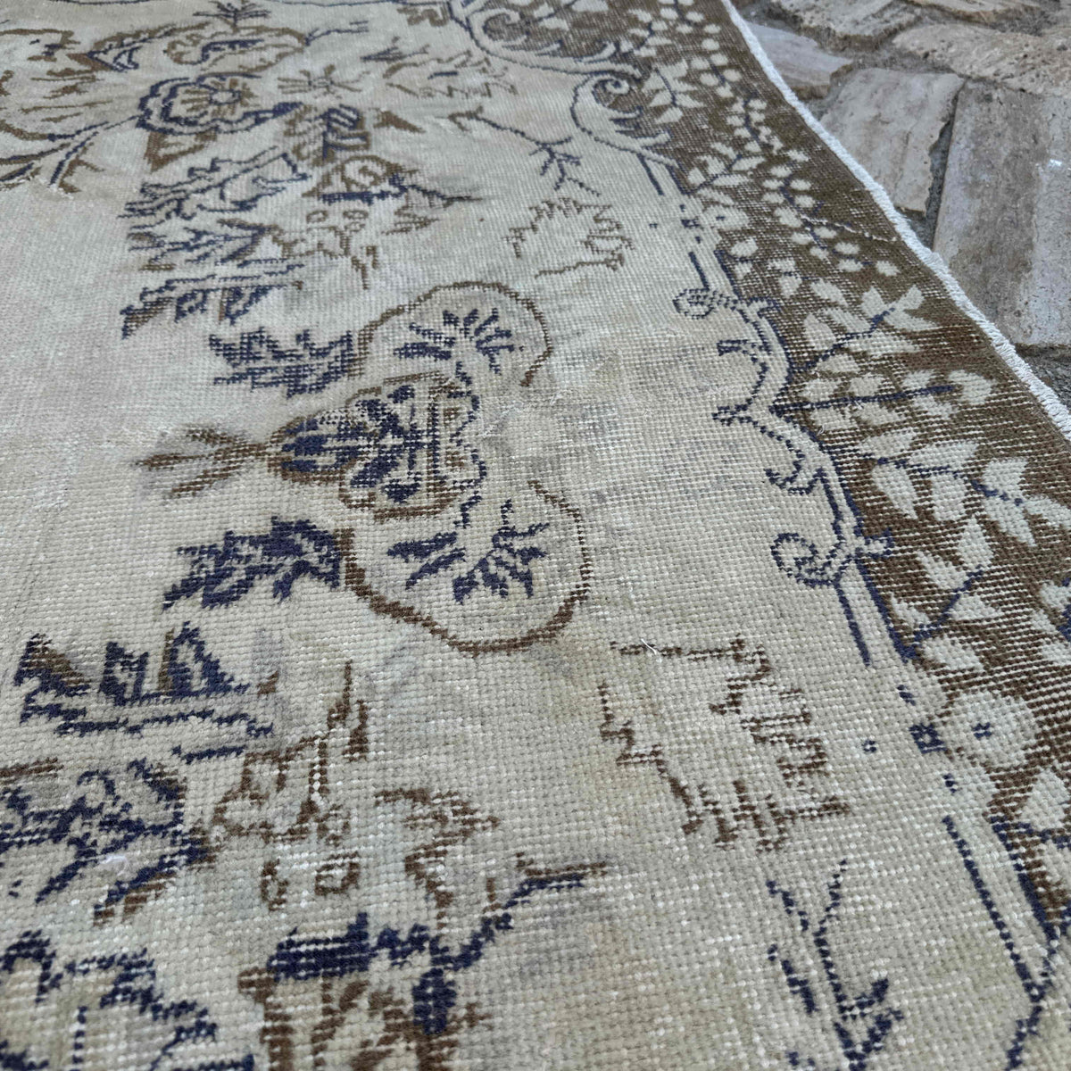 Close-up of the brown vintage turkish rug showing medallion details, hand-knotted weave, wool and cotton and low pile.