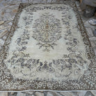 Brown 6' x 10' vintage turkish rug in wool and cotton, shown on the floor.