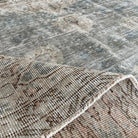 Close-up of the gray vintage turkish rug showing medallion details, hand-knotted weave, wool and cotton and low pile.