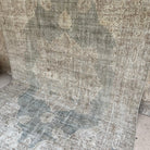 Gray 6' x 10' vintage turkish rug in wool and cotton, shown on the floor.