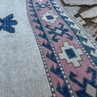 Close-up of the pink vintage turkish rug showing medallion details, hand-knotted weave, wool and cotton and low pile.