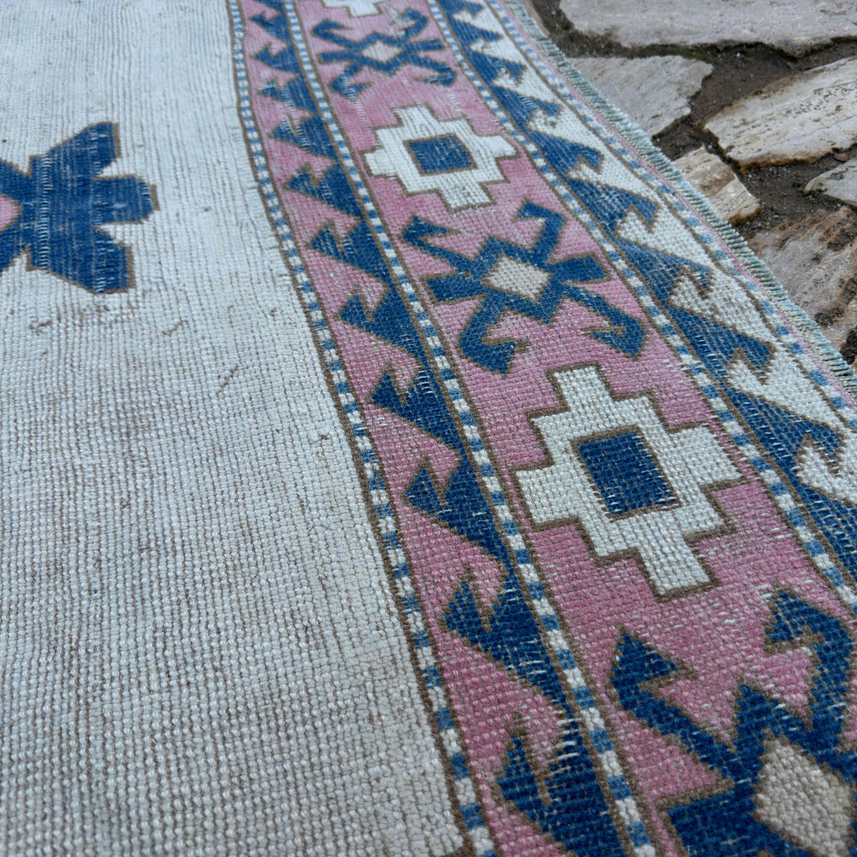 Close-up of the pink vintage turkish rug showing medallion details, hand-knotted weave, wool and cotton and low pile.