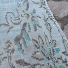 Close-up of the blue vintage turkish rug showing medallion details, hand-knotted weave, wool and cotton and low pile.