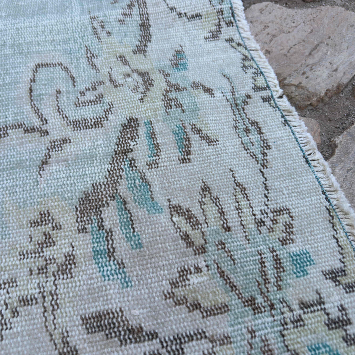 Close-up of the blue vintage turkish rug showing medallion details, hand-knotted weave, wool and cotton and low pile.