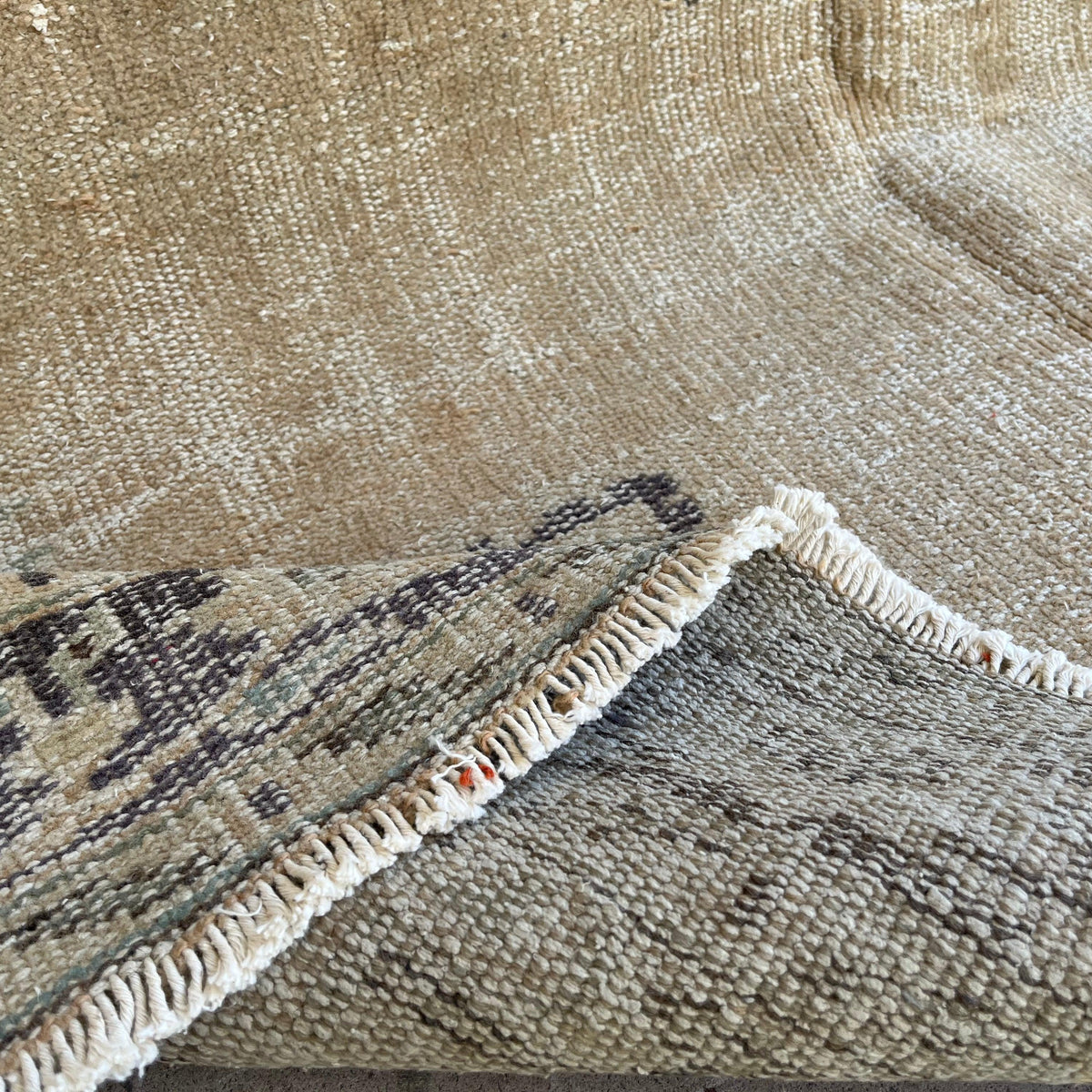 Close-up of the blue vintage turkish rug showing medallion details, hand-knotted weave, wool and cotton and low pile.