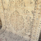 Beige 6' x 9' vintage turkish rug in wool and cotton, shown on the floor.