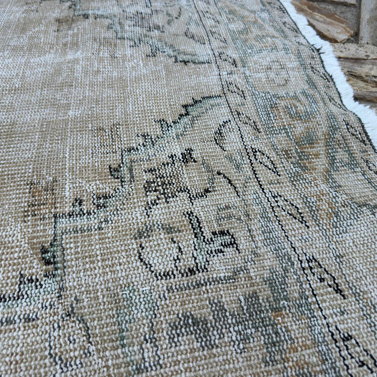 Close-up of the beige vintage turkish rug showing neutral details, hand-knotted weave, wool and cotton and low pile.