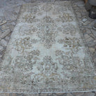 Beige 6' x 9' vintage turkish rug in wool and cotton, shown on the floor.