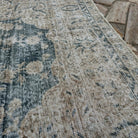 Close-up of the blue vintage turkish rug showing medallion details, hand-knotted weave, wool and cotton and low pile.