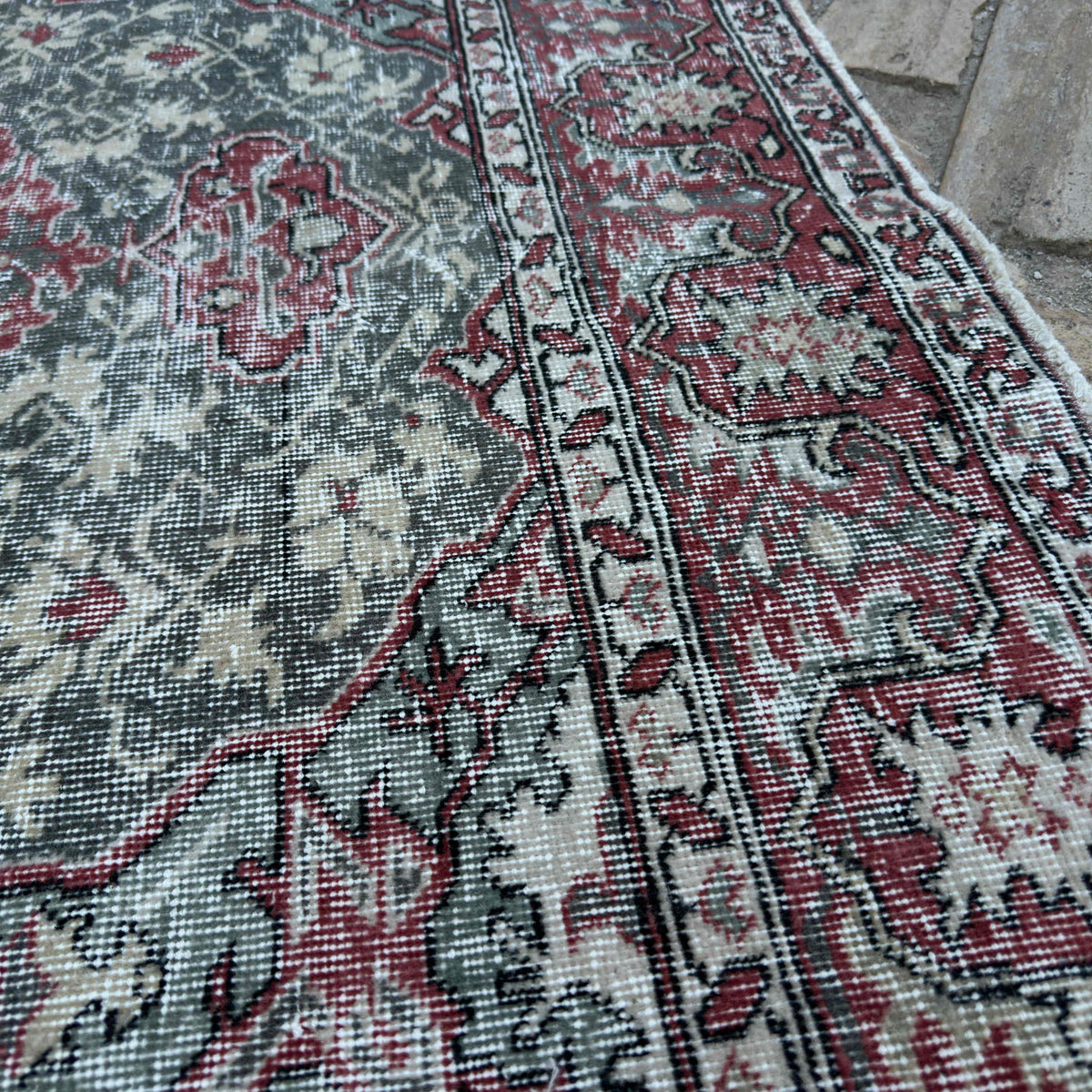 Close-up of the green vintage turkish rug showing traditional details, hand-knotted weave, wool and cotton and low pile.