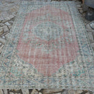 Pink 6' x 9' vintage turkish rug in wool and cotton, shown on the floor.