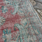 Close-up of the red vintage turkish rug showing medallion details, hand-knotted weave, wool and cotton and low pile.