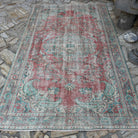Red 6' x 9' vintage turkish rug in wool and cotton, shown on the floor.