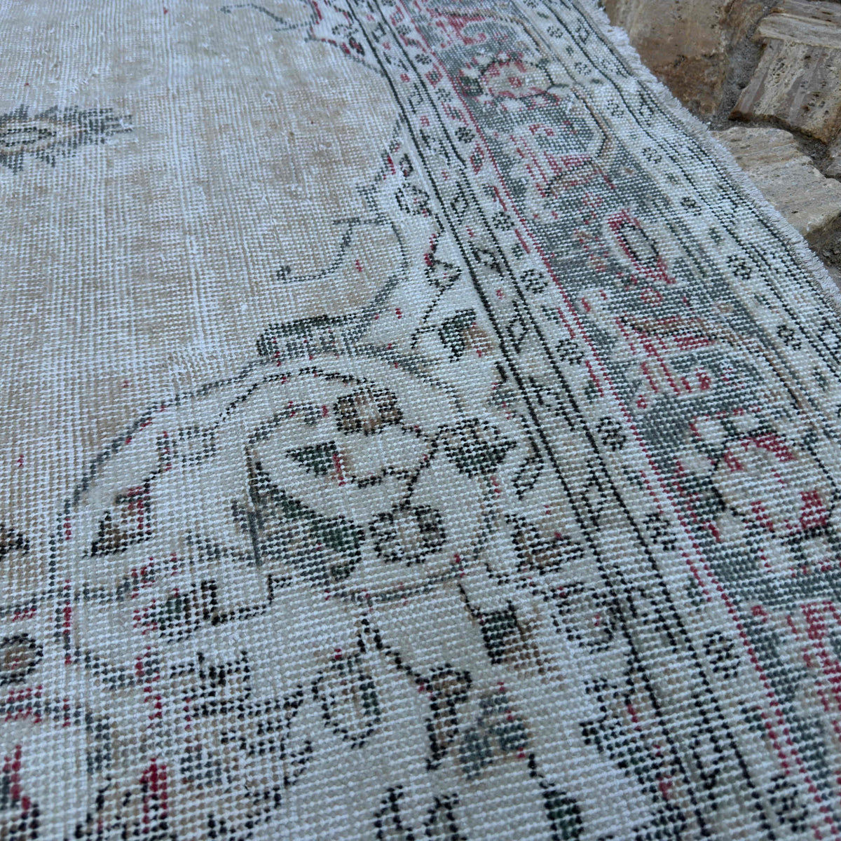 Close-up of the beige vintage turkish rug showing medallion details, hand-knotted weave, wool and cotton and low pile.