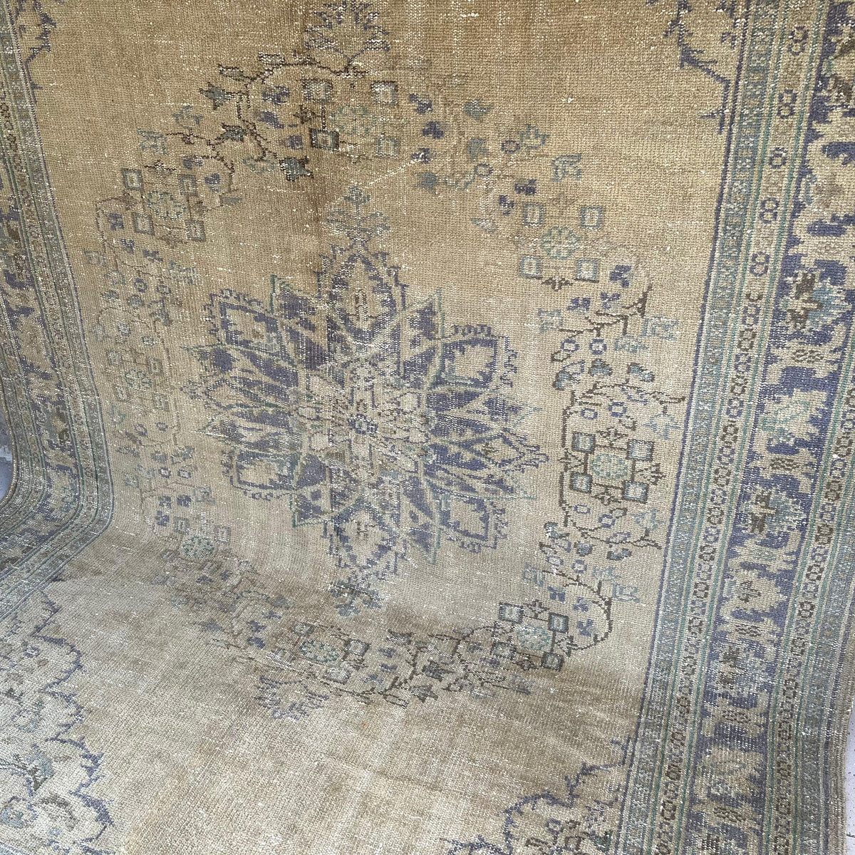 Beige 7' x 10' vintage turkish rug in wool and cotton, shown on the floor.