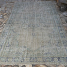 Beige 7' x 10' vintage turkish rug in wool and cotton, shown on the floor.