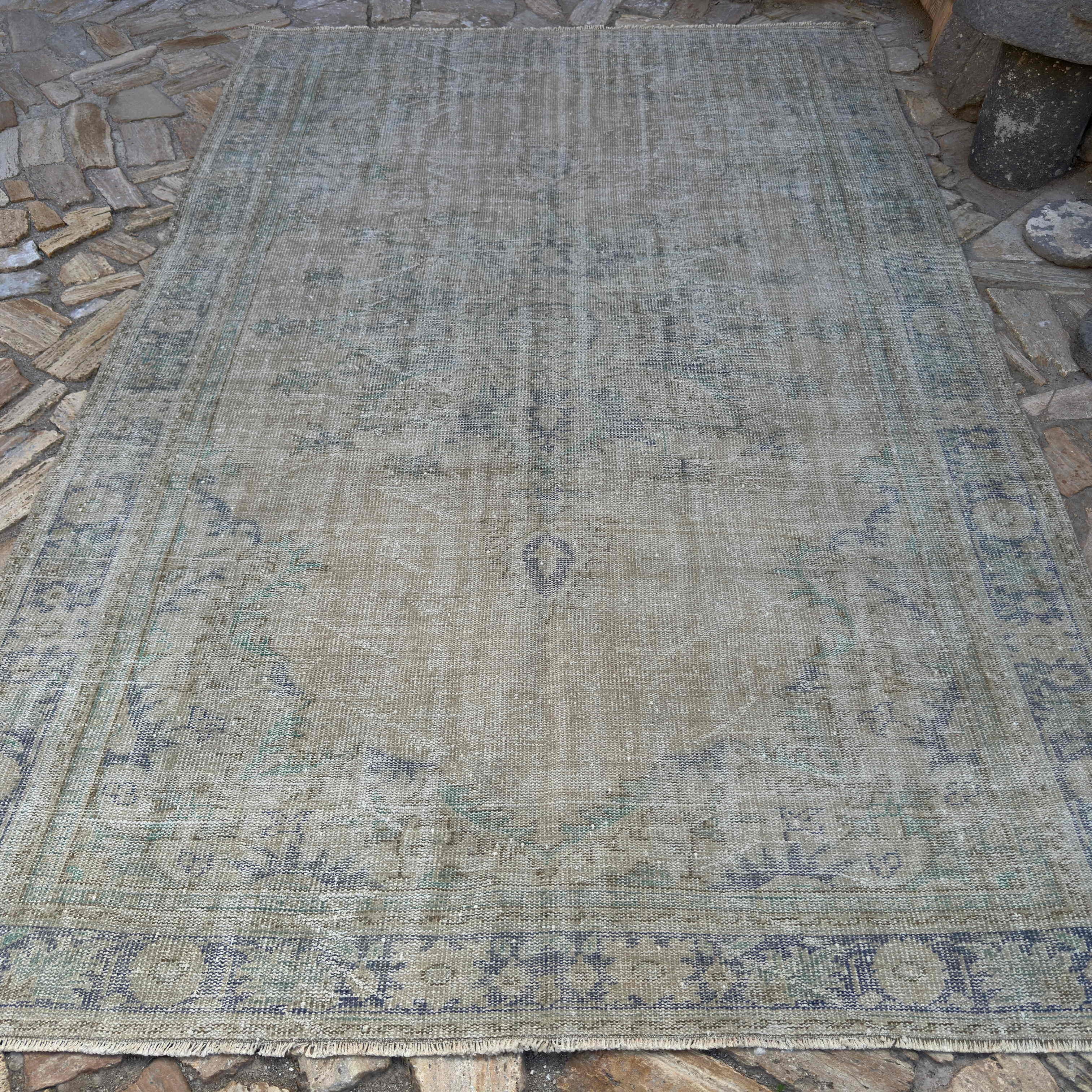Beige 7' x 10' vintage turkish rug in wool and cotton, shown on the floor.