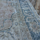 Close-up of the blue vintage turkish rug showing neutral details, hand-knotted weave, wool and cotton and low pile.