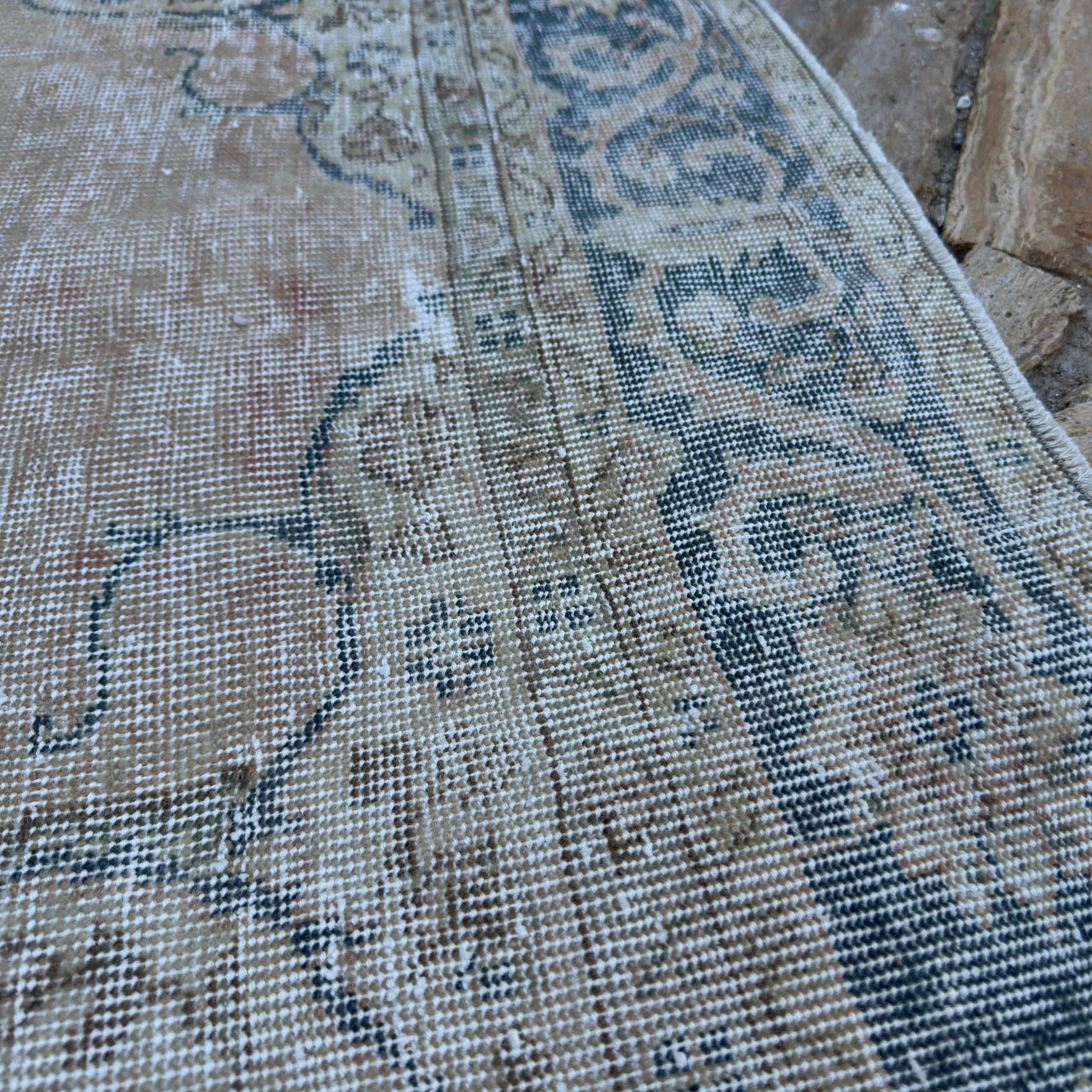 Close-up of the blue vintage turkish rug showing neutral details, hand-knotted weave, wool and cotton and low pile.