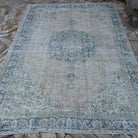Blue 7' x 10' vintage turkish rug in wool and cotton, shown on the floor.