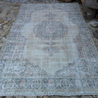 Blue 7' x 10' vintage turkish rug in wool and cotton, shown on the floor.