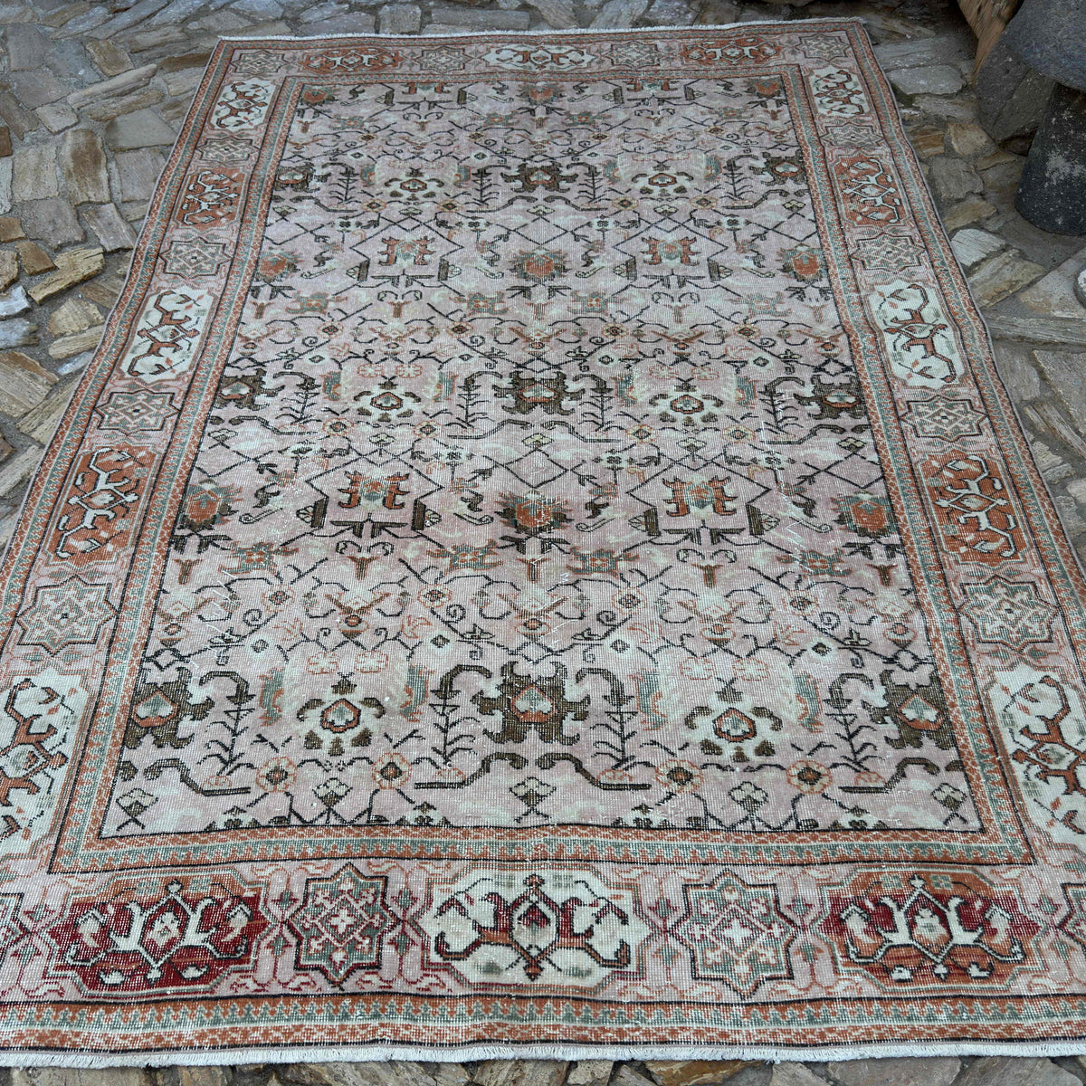 Pink 7' x 10' vintage turkish rug in wool and cotton, shown on the floor.