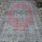 Red 7' x 10' vintage turkish rug in wool and cotton, shown on the floor.