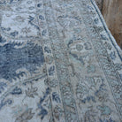 Close-up of the beige vintage turkish rug showing neutral and medallion details, hand-knotted weave, wool and cotton and low pile.