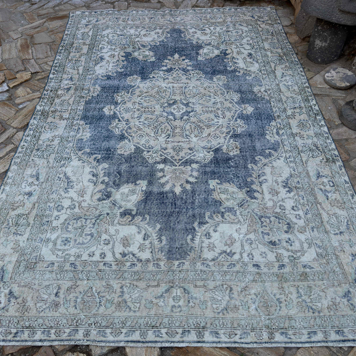 Beige 7 ' x 11' vintage turkish rug in wool and cotton, shown on the floor.