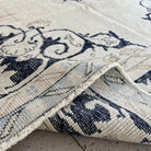 Close-up of the blue vintage turkish rug showing neutral details, hand-knotted weave, wool and cotton and low pile.