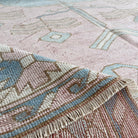 Close-up of the pink vintage turkish rug showing medallion details, hand-knotted weave, wool and cotton and low pile.