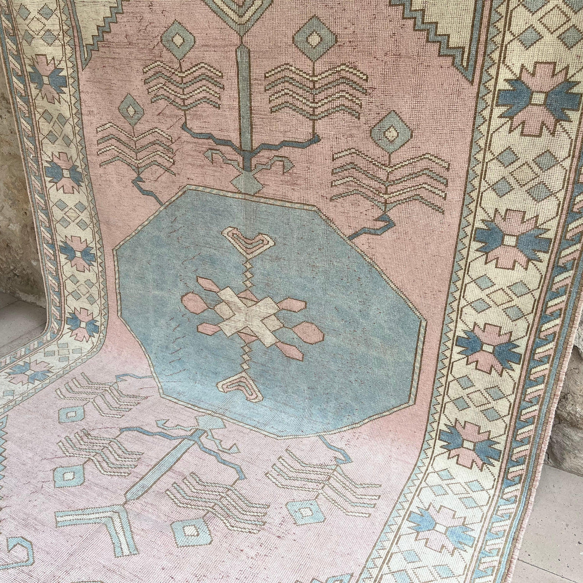 Pink 7' x 11' vintage turkish rug in wool and cotton, shown on the floor.