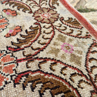 Close-up of the pink vintage turkish rug showing floral and geometric details, hand-knotted weave, wool and cotton and low pile.
