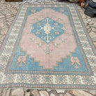 Pink 7' x 11' vintage turkish rug in wool and cotton, shown on the floor.