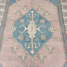 1970s pink vintage turkish rug with medallion design, hand-knotted weave and low pile.