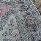 Close-up of the pink vintage turkish rug showing medallion details, hand-knotted weave, wool and cotton and low pile.