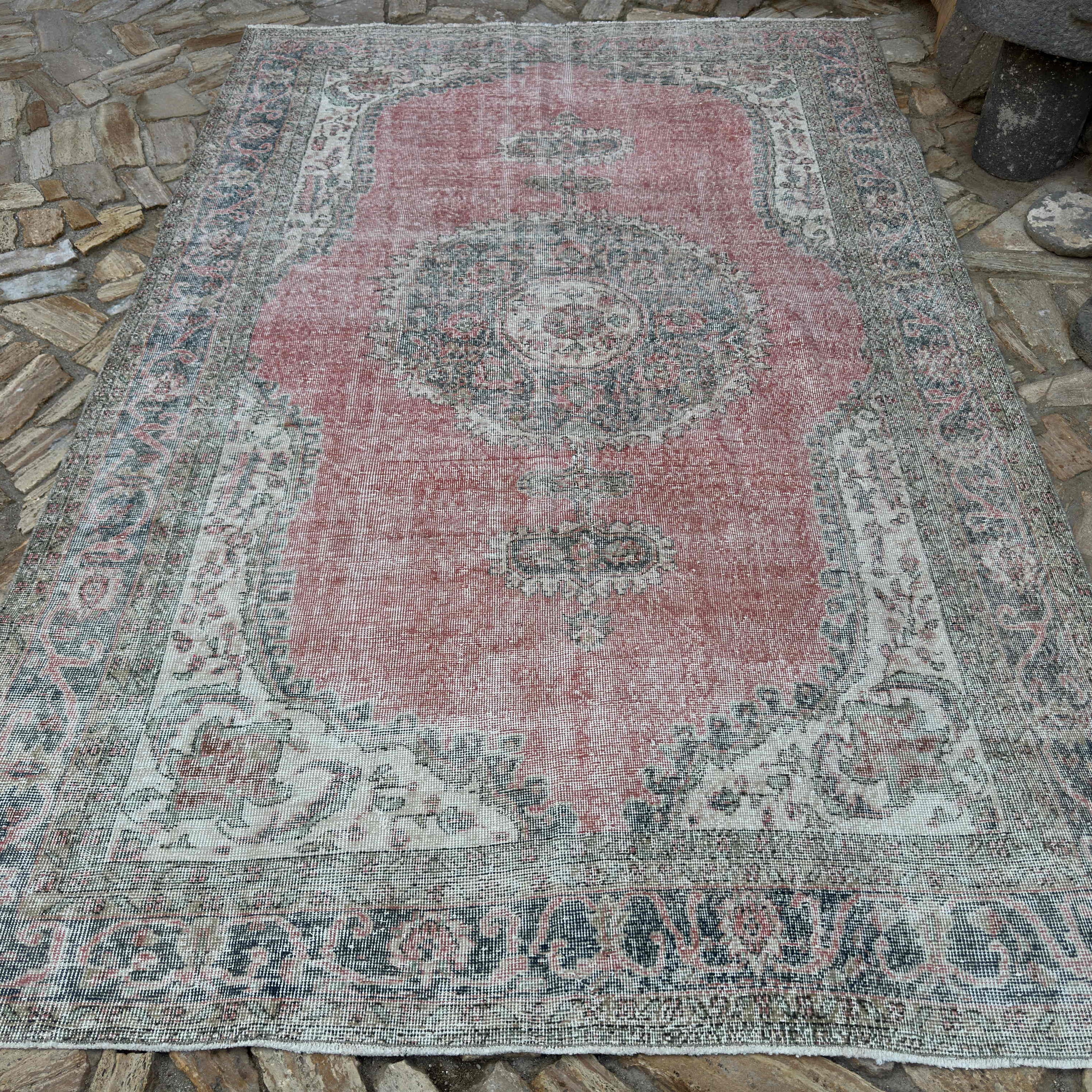 Pink 7' x 11' vintage turkish rug in wool and cotton, shown on the floor.