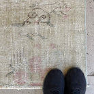 Beige 7' x 8' vintage turkish rug in wool and cotton, shown on the floor.