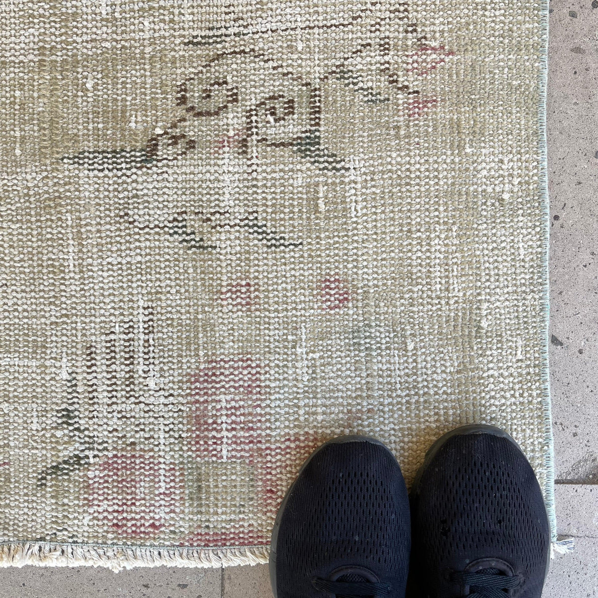 Beige 7' x 8' vintage turkish rug in wool and cotton, shown on the floor.