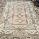 Beige 7' x 9' vintage turkish rug in wool and cotton, shown on the floor.