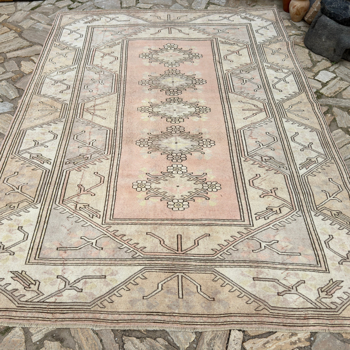 Beige 7' x 9' vintage turkish rug in wool and cotton, shown on the floor.