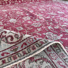 Close-up of the red vintage turkish rug showing floral details, hand-knotted weave, wool and cotton and low pile.