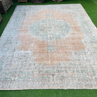 Orange 9' x 11' vintage turkish rug in wool and cotton, shown on the floor.
