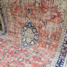 Pale Red 9' x 11' vintage turkish rug in wool and cotton, shown on the floor.
