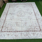 Beige 9' x 12' vintage turkish rug in wool and cotton, shown on the floor.