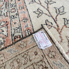 Close-up of the pink vintage turkish rug showing floral and neutral details, hand-knotted weave, wool and cotton and low pile.