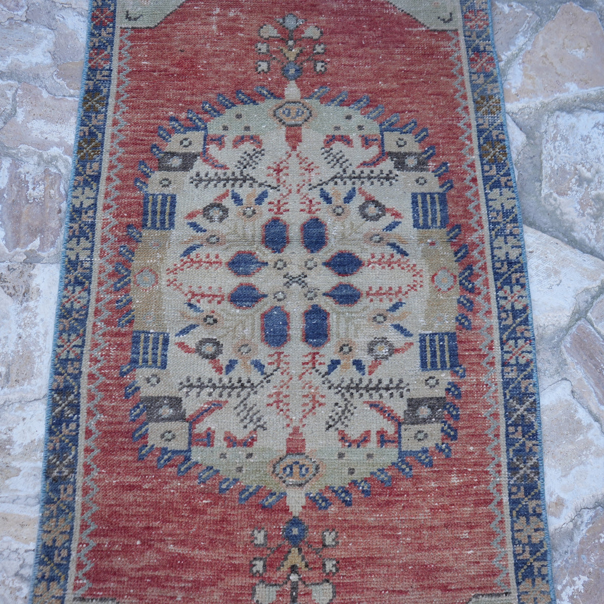Close-up of the red vintage turkish rug, hand-knotted weave, wool and cotton and low pile.