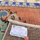 Close-up of the orange vintage turkish runner rug showing geometric details, hand-knotted weave, wool and cotton and low pile.