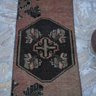 Close-up of the pale red vintage turkish runner rug showing traditional details, hand-knotted weave, wool and cotton and low pile.