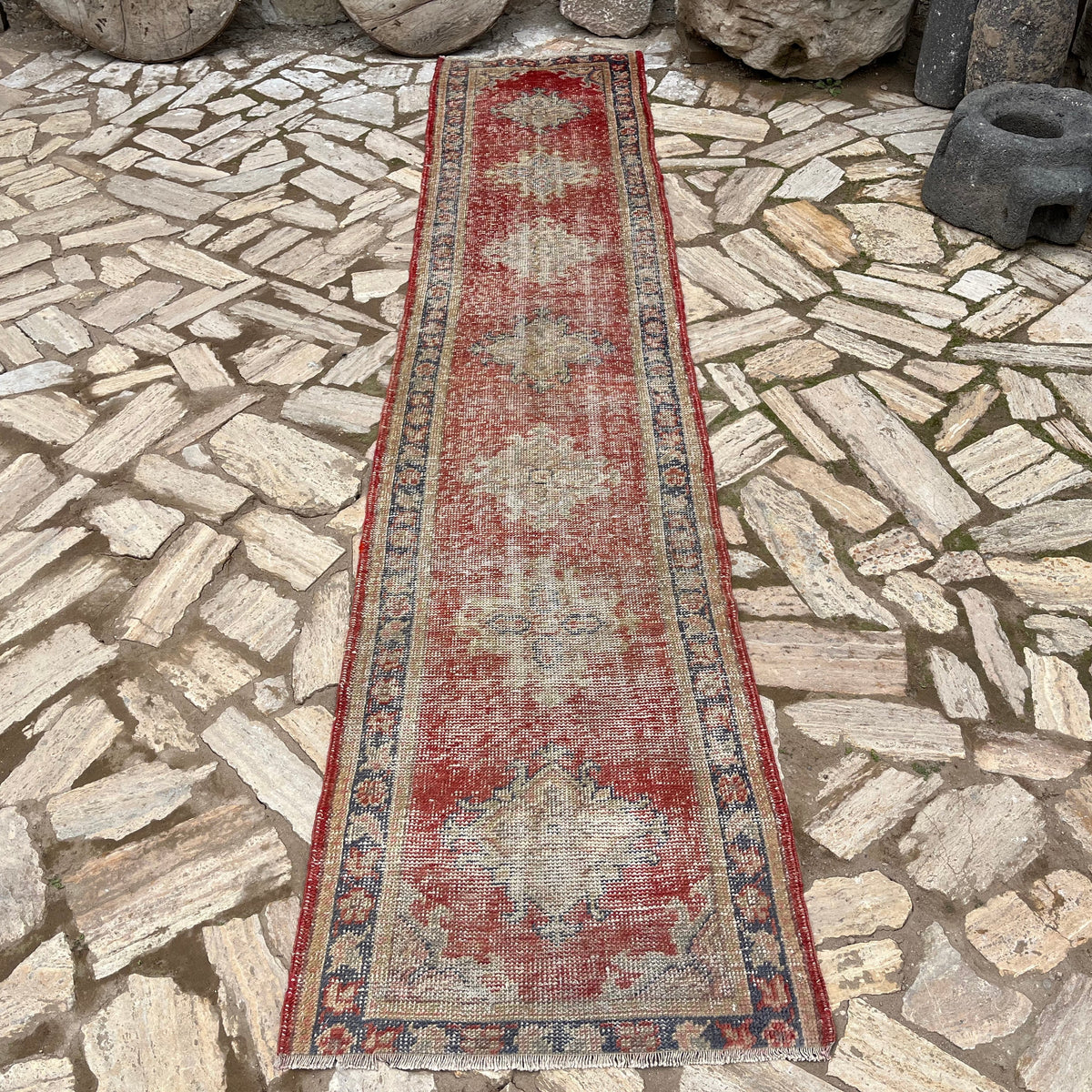 Red 2' x 11' vintage turkish runner rug in wool and cotton, shown on the floor.